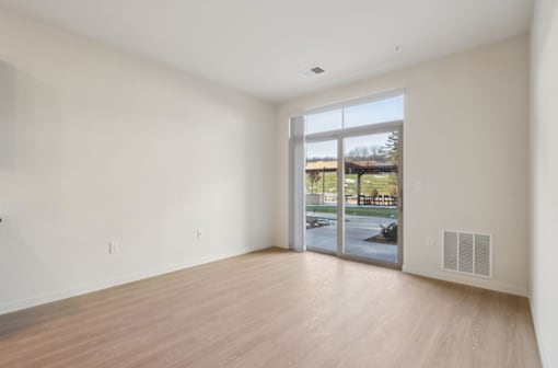 A room with a sliding glass door leading to a patio.