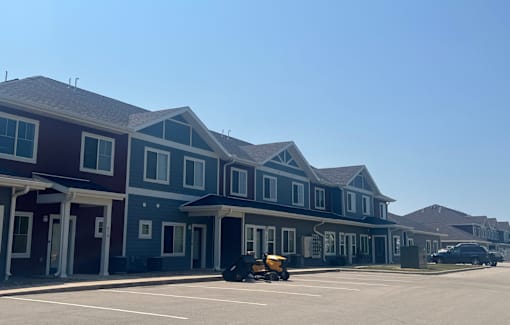 A row of houses with a yellow vehicle in front.