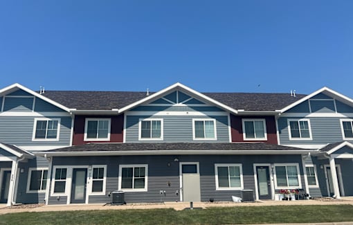 A row of houses with grey and red trim.