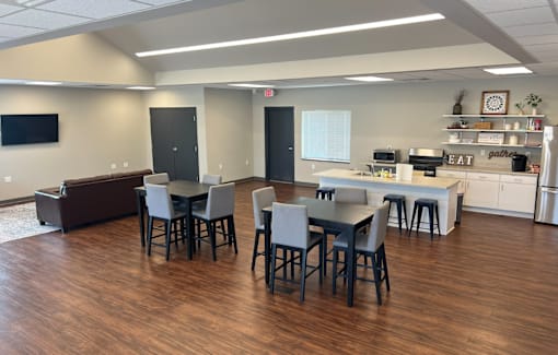 A room with a dining table and chairs.