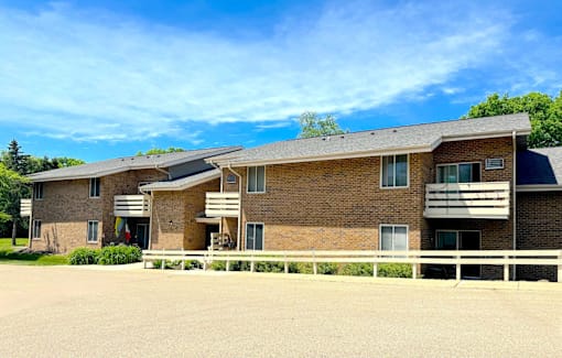 A large brick building with a white fence in front.