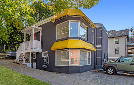 A house with a yellow awning and a balcony.