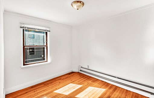 A room with a window and wooden floor.