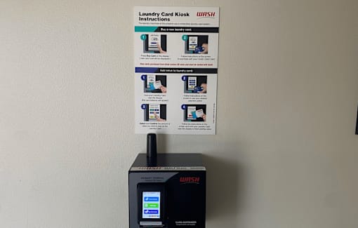 A WASH machine with instructions on how to use the card kiosk.