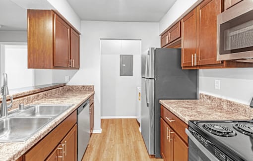 A kitchen with wooden cabinets and a black refrigerator.