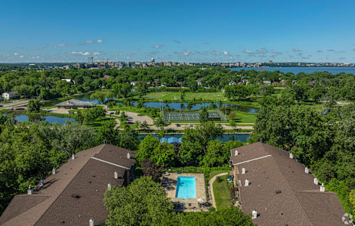 A bird's eye view of a residential area with houses, a swimming pool, and a lake.