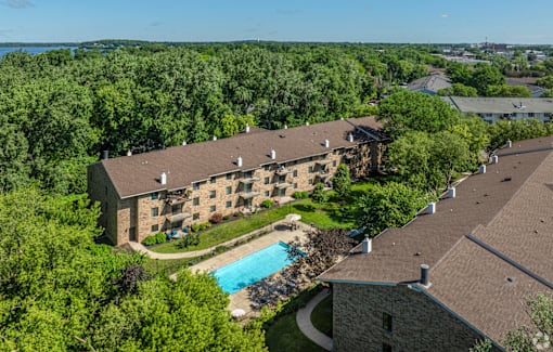 A large building with a pool surrounded by trees.