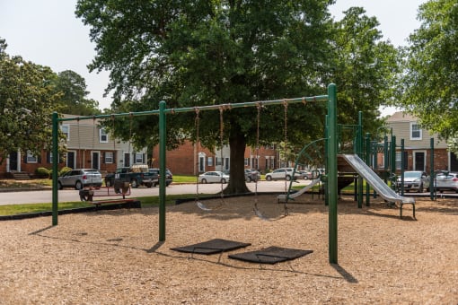 a playground with a swing set and a tree