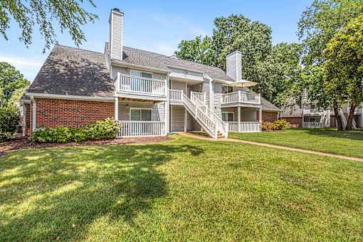 A house with a red brick chimney and a white porch.