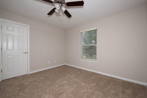 a bedroom with carpet and a ceiling fan
