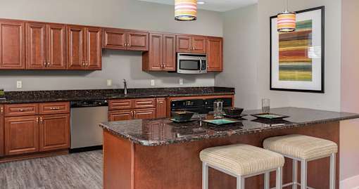 A kitchen with brown cabinets and a granite countertop.