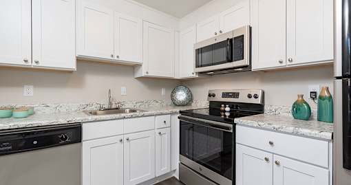 A kitchen with white cabinets and stainless steel appliances