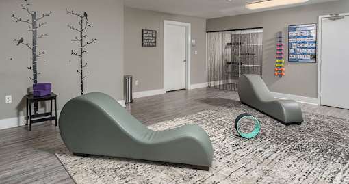 A yoga studio with weights and chairs