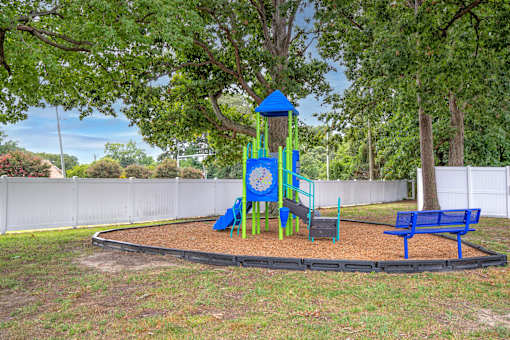 A playground with a blue slide and a blue bench.