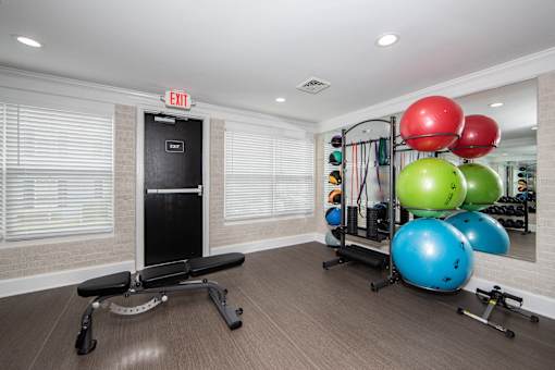 A gym with a bench, weights, and a mirror.