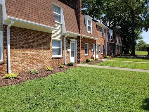 A row of houses with red brick and white trim.