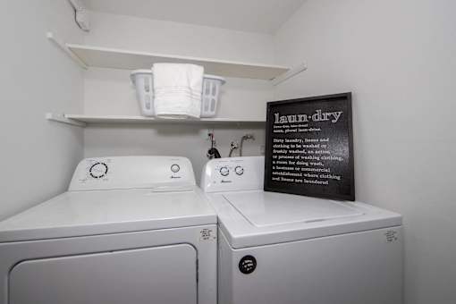 Laundry room with washer and dryer and sign.