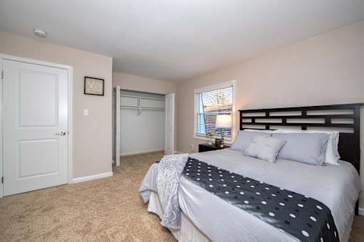 A bedroom with a bed, a window, and a door.