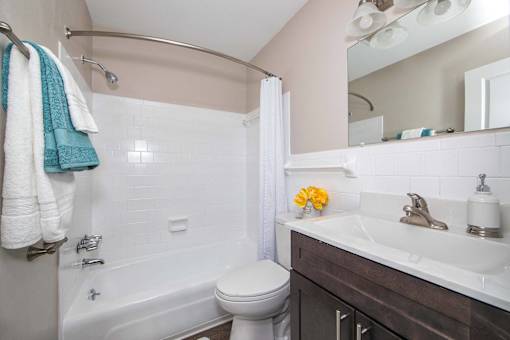 A white toilet sits next to a white sink in a bathroom.