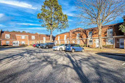 A parking lot with cars and apartment buildings in the background.