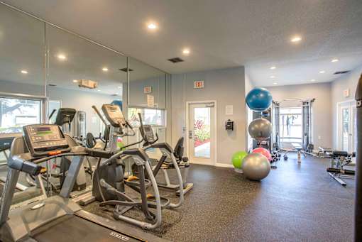 A gym with treadmills, exercise balls, and other equipment.