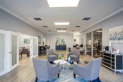 A spacious waiting room with grey chairs and a coffee table.