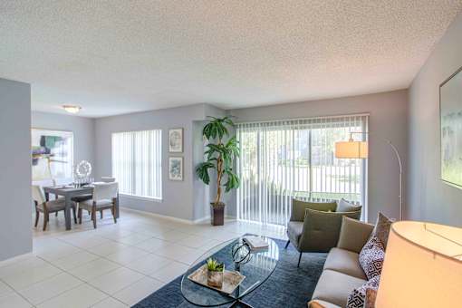 A living room with a couch, coffee table, and dining table.