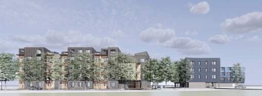 A modern building complex with trees in front.