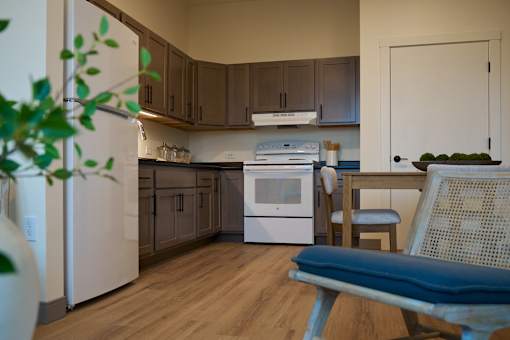 A kitchen with a white refrigerator, a white oven, and brown cabinets.