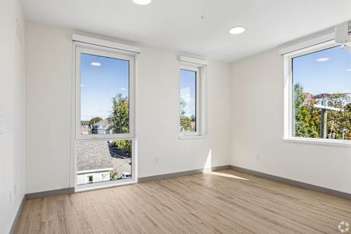A room with two windows and wooden flooring.
