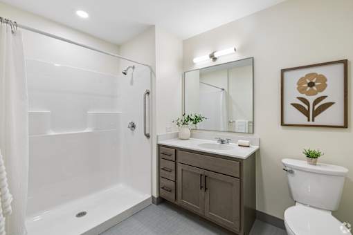 A bathroom with a white toilet, a white sink, a white bathtub, and a brown cabinet.