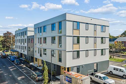 A modern building with a parking lot in front.