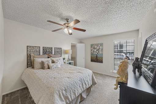 Master bedroom with ceiling fan and decor at Parks on the Green Apartments, Temple, Texas