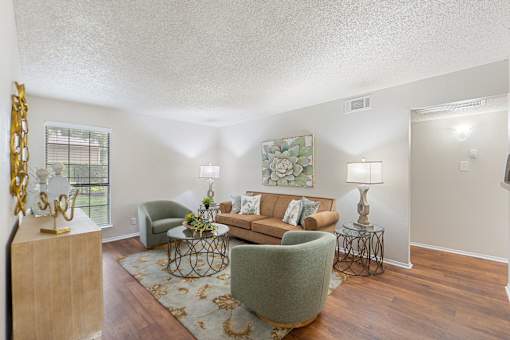 Furnished living room with sage armchairs at Parks on the Green Apartments, Temple