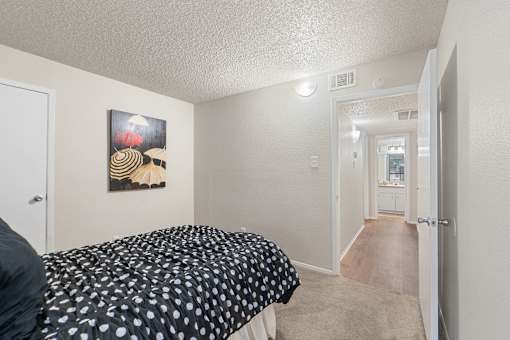 Bedroom with hallway view and umbrella artwork at Parks on the Green Apartments, Temple, TX