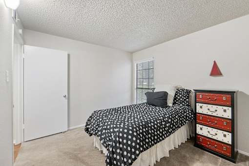 Bedroom with black polka dot bedding and colorful dresser at Parks on the Green Apartments, Temple, 76504