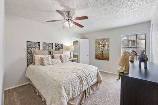 Master bedroom with textured bedding and window at Parks on the Green Apartments, Temple, Texas
