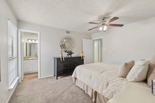 Master bedroom with ensuite bathroom and black dresser at Parks on the Green Apartments, Temple