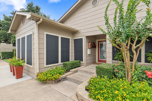 Front entrance with landscaped beds and accent door at Parks on the Green Apartments, Temple, TX