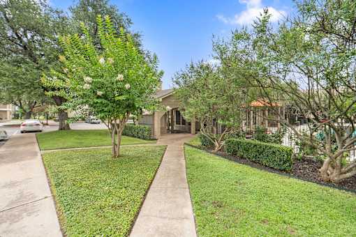 Front yard with mature trees and sidewalk at Parks on the Green Apartments, Temple, 76504