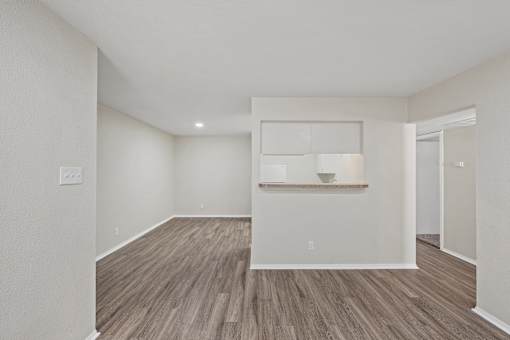 Open concept living area with white kitchen pass through at Parks on the Green Apartments, Temple, Texas