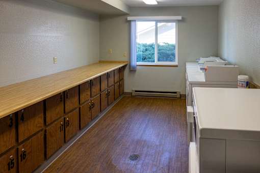 A room with a long wooden table and drawers on the side.