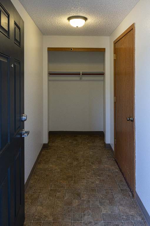 A hallway with a tiled floor and a light on the ceiling.