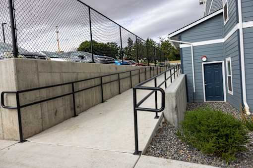 A blue building with a black fence and a red circle on the door.