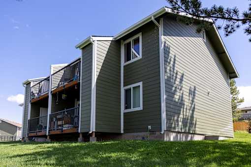 A house with a grey siding and a balcony.