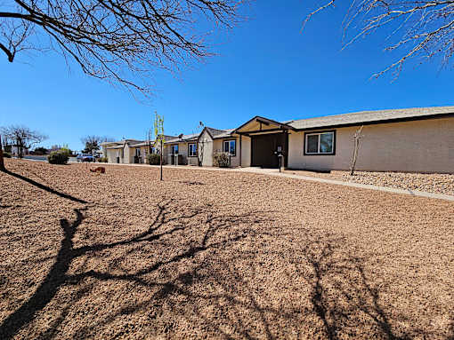 A row of houses with bare trees in front of them.