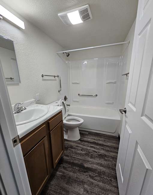 A white bathroom with a toilet, sink, and bathtub.
