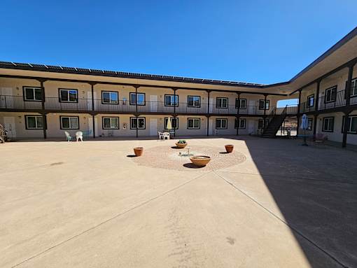 A courtyard with a concrete floor and a building with balconies in the background.