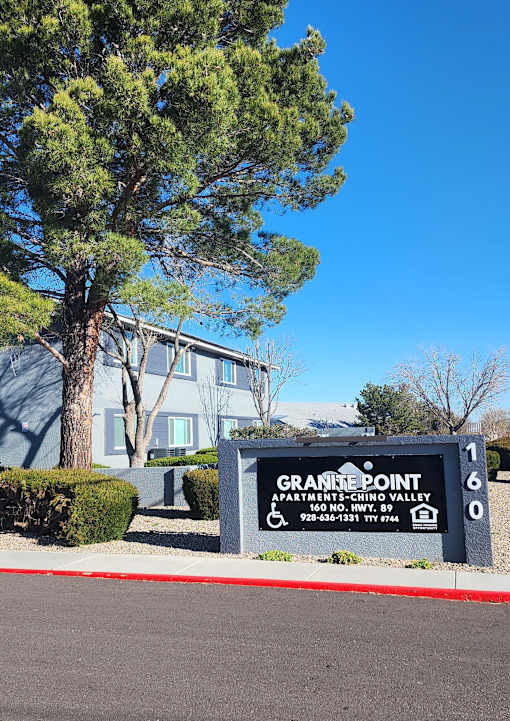 A sign for Granite Point Apartments sits in front of a building.