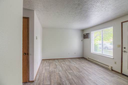 A room with wooden flooring and white walls.